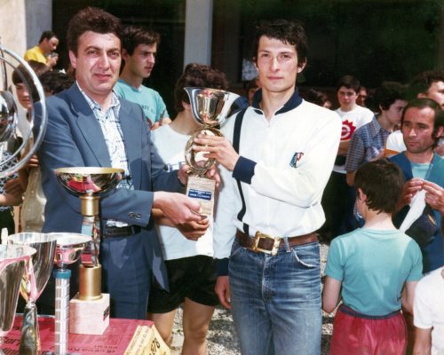 Nando Cremonesi, direttore del Corpo Filarmonico Cittadino tra gli anni '70 e '80, premia un partecipante alla "Marcia del Corpo Filarmonico" organizzata durante i festeggiamenti del 125° anniversario.